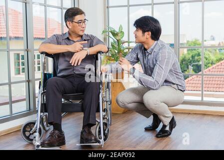 Alter Mann im Rollstuhl und sein kleiner Sohn Stockfoto