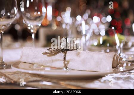 Exquisite Tischeinstellung für das neue Jahr. Die Stoffserviette ist mit einem vintage Hirschkopf Ring gesichert. Makrofoto. Speicherplatz kopieren. Teures Restaurant. Stockfoto