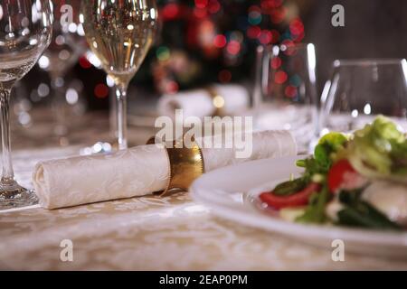 Schöne Tischkulisse für das neue Jahr. Ein Vintage-Ring sichert die Stoffserviette. Das Konzept eines Urlaubs in einem teuren Restaurant. Stockfoto