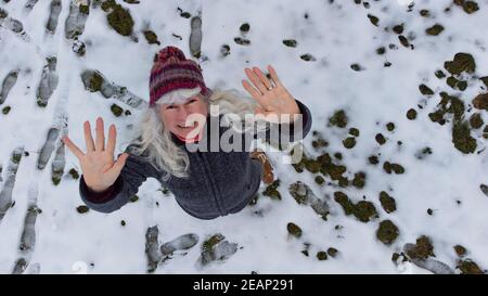 Mit einer Drohne erschossen. Eine Frau winkt in Richtung Himmel Stockfoto