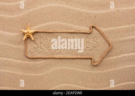 Pfeil aus Seil und Muscheln mit dem Wort Seychellen auf dem Sand Stockfoto