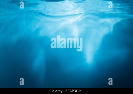 Abstrakter blauer Hintergrund. Wasser mit Sonnenstrahlen Stockfoto