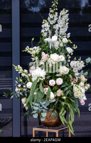 Beeindruckendes floristisches Bouquet von weißen Rosen und Delphinium - grün Drehen Stockfoto