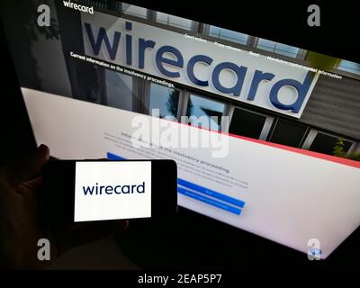 Person, die Smartphone mit Logo des deutschen Zahlungs- und Finanzdienstleisters Wirecard AG vor der Website hält. Konzentrieren Sie sich auf die Telefonanzeige. Stockfoto