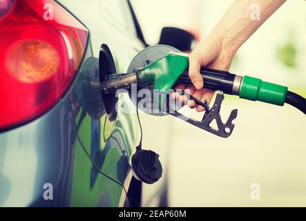 Man pumpt Benzin Kraftstoff im Auto an Tankstelle Stockfoto