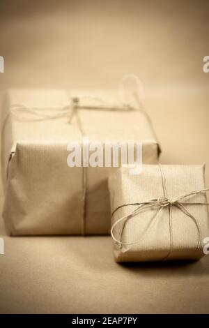 Zwei Geschenk-Paket mit einfachem braunem Papier und Seil und braunem Papier Hintergrund Textur, retro Geschenkbox verpackt. Present Konzept Stockfoto