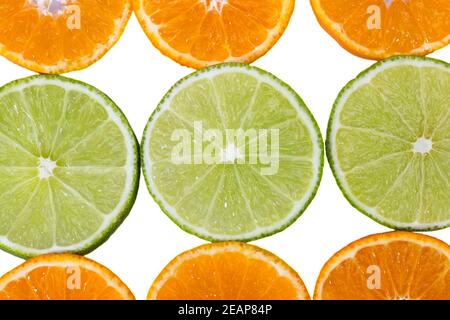 Fruchtscheiben aus Mandarine und grüner Limette isoliert auf weißem Hintergrund, Nahaufnahme Stockfoto