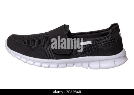 Schwarze Schuhe von Mans. Nahaufnahme eines einzelnen schwarzen Sneakers oder Sportschuhs isoliert auf weißem Hintergrund. Beschneidungspfad enthalten. Elegante und trendige Herrenschuhe. Makro. Stockfoto