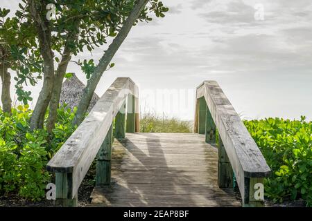 Holzbrücke zu einem Sandstrand auf Sanibel Island in Florida Stockfoto