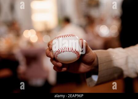 Baseball Ball mit roten Nähten in der Hand Stockfoto