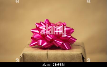 Braun einfarbig Papier Geschenkbox mit rosa Verpackung Dekoration auf braunem Hintergrund, Geschenk-und Geburtstagskonzept, Retro-Design Stockfoto