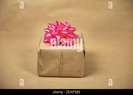 Braun einfarbig Papier Geschenkbox mit rosa Verpackung Dekoration auf braunem Hintergrund, Geschenk-und Geburtstagskonzept, Retro-Design Stockfoto