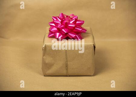 Braun einfarbig Papier Geschenkbox mit rosa Verpackung Dekoration auf braunem Hintergrund, Geschenk-und Geburtstagskonzept, Retro-Design Stockfoto