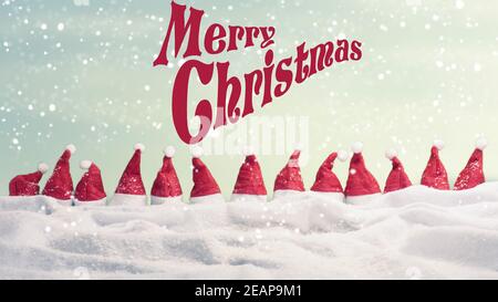 Frohe Weihnachten mit vielen Hüten von Santa in einer Reihe Mit Schneeflocken Stockfoto