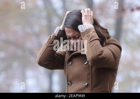 Verzweifelte Frau, die sich allein in einem Park beschwert Stockfoto