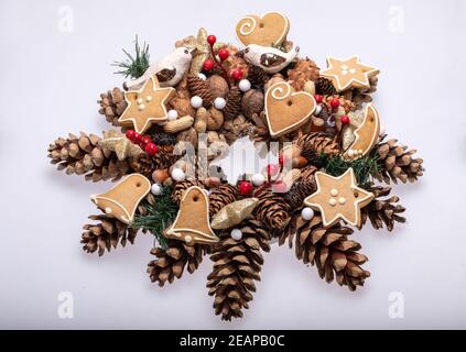 Weihnachtsschmuck mit Tannenzapfen, Nüssen und handgefertigten Weihnachtsplätzchen Stockfoto