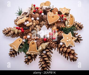 Weihnachtsschmuck mit Tannenzapfen, Nüssen und handgefertigten Weihnachtsplätzchen Stockfoto