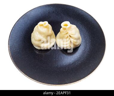 Zwei gedämpfte Buuz-Knödel auf dunkler Platte isoliert Stockfoto