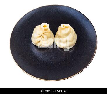Zwei gekochte Buuz Knödel auf dunklem Teller isoliert Stockfoto