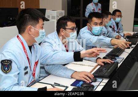 (210210) -- PEKING, 10. Februar 2021 (Xinhua) -- Technisches Personal überwacht Chinas Sonde Tianwen-1 im Beijing Aerospace Control Center in Peking, Hauptstadt von China, 10. Februar 2021. Chinas Sonde Tianwen-1 ist am Mittwoch nach einer fast siebenmonatigen Reise von der Erde erfolgreich in die Umlaufbahn um den Mars eingedrungen. (CNSA/Handout über Xinhua) Stockfoto