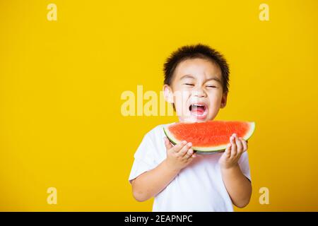 Kind niedlich kleiner Junge attraktiv lachen Lächeln spielen hält geschnitten Wassermelone frisch zum Essen Stockfoto