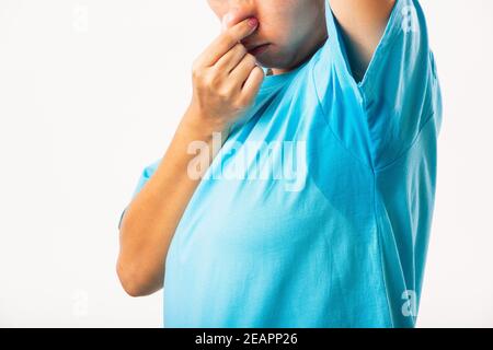 Weibliche Achselhöhle Schweißfleck auf ihre Kleidung stinkenden Hand verwenden Nase schließen Stockfoto