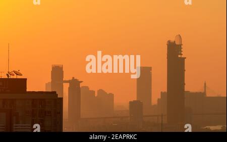 Luftverschmutzung in Bangkok, Thailand. Smog und Feinstaub von PM2,5 bedeckten Stadt am Morgen mit orangefarbenem Sonnenaufgangshimmel. Stadtbild mit verschmutzter Luft. Schmutzige Umgebung. Giftiger Staub in der Stadt. Ungesunde Luft. Stockfoto