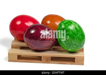 Bunte Ostereier auf einer Holzpalette gegen ein Weiß Hintergrund Stockfoto