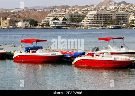 Kleine rot-weiße Mietboote schweben im Hafen von Eilat, Israels südlichster Spitze am Roten Meer. Stockfoto