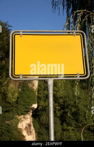 Gelbes Straßenschild auf einem Hintergrund von Bäumen Stockfoto