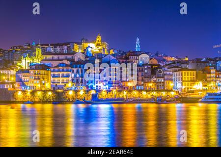 Nachtansicht des torre dos clerigos und der bunten Häuser in Porto, Portugal. Stockfoto