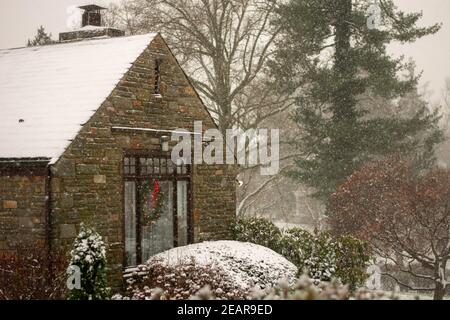 Ein Cobble Suburban Haus und Straße während eines Schneesturms Stockfoto