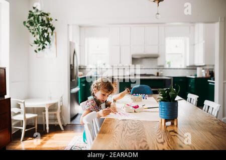 Zwei kleine Kinder, die im modernen Speisesaal Kunst und Kunsthandwerk machen. Stockfoto