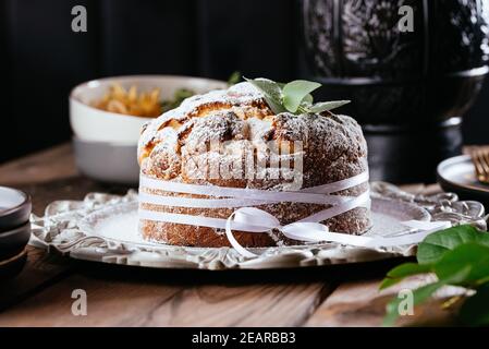 ostern, osterkuchen auf einem dunklen Hintergrund mit einer komplexen Komposition, schöne Landschaft, getrocknete Früchte, Bewegung, Hände Stockfoto