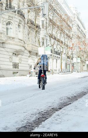 Mann mit Motorrad auf dem Rücken in der Stadt. Stockfoto