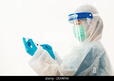 Frau medizinische Wissenschaftlerin in PSA Uniform trägt eine Gesichtsmaske Schutzschild aus Kunststoff für Impfstoff und Spritze Quarantäne Coronavirus Outbreak (COVID-19) isoliert auf weißem Hintergrund Stockfoto