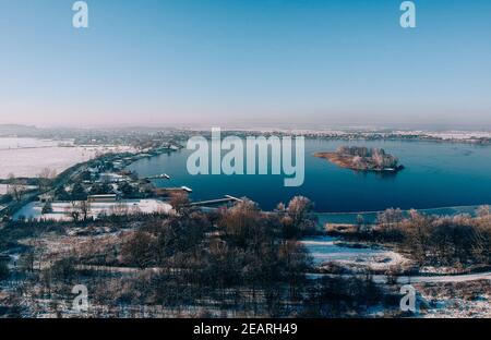 Luftaufnahme eines Sees in der Nähe des von tiefem Schnee bedeckten Landes Stockfoto