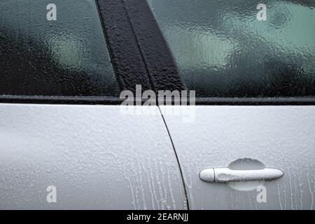 Eisschicht auf weißem Auto nach eisigen Regen Stockfoto