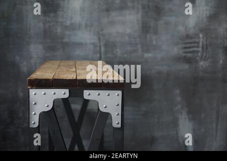 Holztisch mit Metalleinlagen. Tisch im Loft-Stil auf dem Hintergrund einer dunklen Wand im Grunge- und Loft-Stil Stockfoto