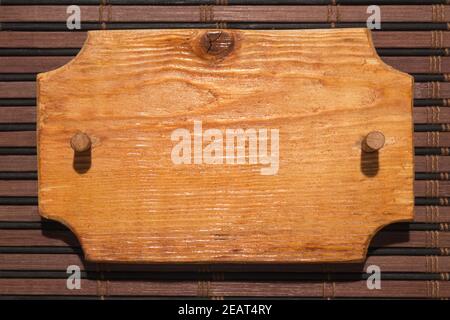 Holz gemusterter Rahmen aus Holz mit einem Holzknebel ist auf einer Bambusmatte. Stockfoto