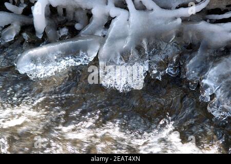 Eiszapfen am Bachlauf Stockfoto