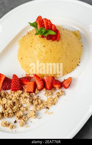 Türkische Dessert Grieß halva. Grieß Dessert mit Zimtpulver und Erdbeere Stockfoto
