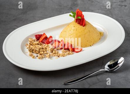 Türkische Dessert Grieß halva. Grieß Dessert mit Zimtpulver und Erdbeere Stockfoto