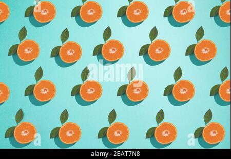 Orangefarbene Mandarine auf aquablauem Hintergrund. Sommer Obst flach Lay stilvoll minimalistisch Konzept Muster. Stockfoto