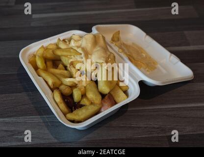 currywurst mit Pommes in eine Tasse. Traditionelle deutsche Küche mit Dip zu Corona Zeiten gehen Stockfoto