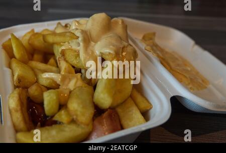 currywurst mit Pommes in eine Tasse. Traditionelle deutsche Küche mit Dip zu Corona Zeiten gehen Stockfoto