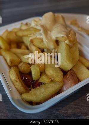 currywurst mit Pommes in eine Tasse. Traditionelle deutsche Küche mit Dip zu Corona Zeiten gehen Stockfoto