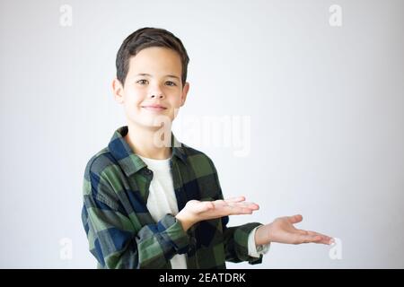 Schöne junge über isoliert weißen Hintergrund überrascht, zeigt und zeigt etwas, das auf ihrer Hand ist Stockfoto