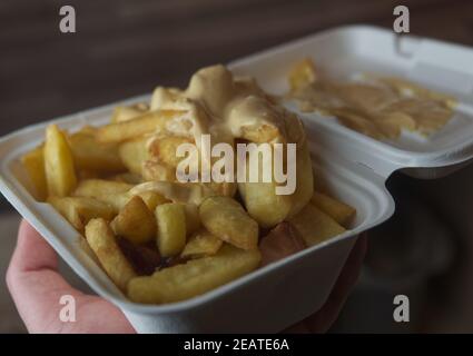 currywurst mit Pommes in eine Tasse. Traditionelle deutsche Küche mit Dip zu Corona Zeiten gehen Stockfoto