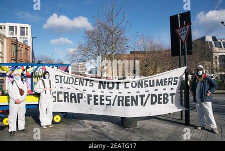 Student Rent Strike, Lower Marsh Street, London, Großbritannien 10th. Februar 2021. Schüler in Hazmat Anzüge und Masken halten Banner, die besagt, dass die sind "tudents nicht Verbraucher". Sie protestieren gegen hohe Mieten und Gebühren zu zahlen, während sie wenig in der Art der Ausbildung oder Unterkunft wegen der laufenden Covid 19 Pandemie Kredit erhalten: Denise Laura Baker/Alamy Live News Stockfoto